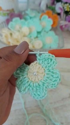 someone is crocheting flowers with yarn on the table