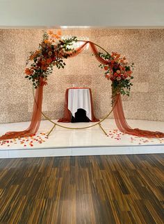 an orange and white wedding arch with flowers on it