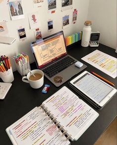 an open laptop computer sitting on top of a desk next to a cup of coffee