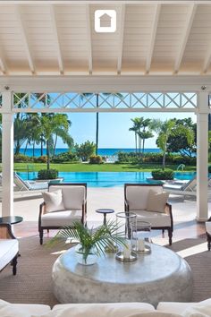 a living room filled with furniture next to a swimming pool