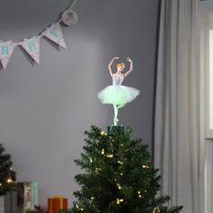 a small christmas tree with a ballerina figure on top