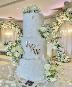 a wedding cake with white flowers and greenery