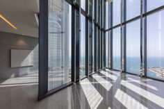 an empty room with large windows overlooking the ocean