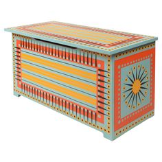 an orange, blue and yellow box with designs on the lid is sitting in front of a white background