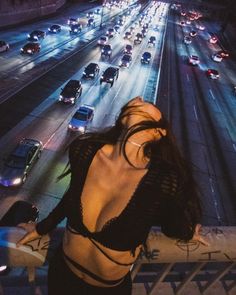 a woman standing on the side of a road at night