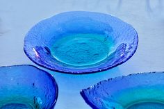 three blue bowls sitting on top of a table