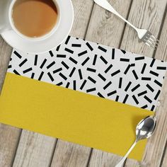 a cup of coffee sitting on top of a yellow place mat