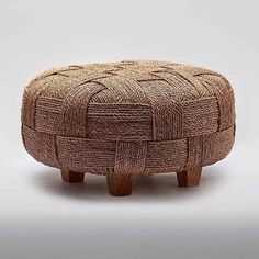 an ottoman made out of woven material with wooden legs and foot rest in the shape of a basket