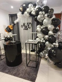 a room filled with balloons and black and white decorations