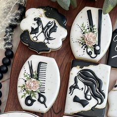 decorated cookies with black and white designs are arranged on a wooden table next to flowers