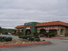 an exterior view of a holiday inn with cars parked in the parking lot and landscaping