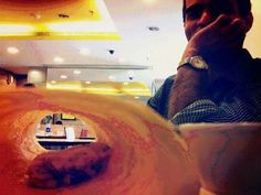 a man sitting at a table with a doughnut in front of him