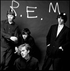 three men standing next to each other in front of a chalkboard with the word rem written on it