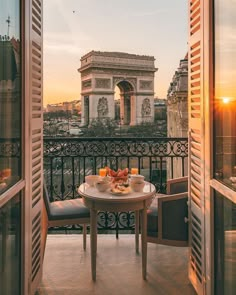 an open balcony with a table and chairs overlooking the eiffel tower