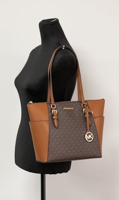 Style: Michael Kors Charlotte Handbag Tote (Brown Signature) Material: PVC/Leather Features: MK Logo on Front, Zip Closure, MK logo charm, Exterior Pocket Measures: 10" L x 15" W x 4.5" D MSRP: $398 Luxury Tote Bags Michael Kors, Michael Kors Shopper Bag, Michael Kors Brown Tote, Cheap Rectangular Michael Kors Shoulder Bag, Cheap Michael Kors Rectangular Shoulder Bag, Brown Business Bag With Logo, Brown Double Handle Shoulder Bag With Logo, Brown Tote Shoulder Bag With Logo, Brown Logo Tote Shoulder Bag