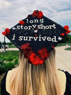 a woman wearing a black graduation cap with red flowers on it's side and the words long story short i survived