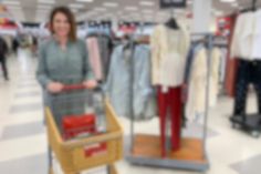 a woman pushing a shopping cart through a store