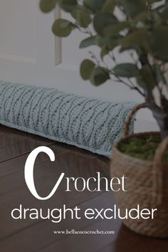 the crochet pillow is next to a potted plant on a wooden floor