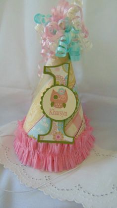 a pink and blue birthday hat on top of a doily