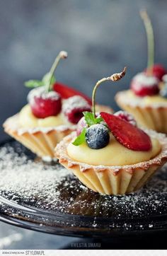 small desserts with berries and powdered sugar on a plate