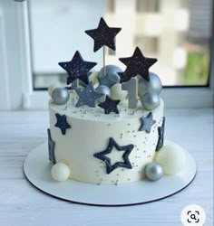 a white cake with stars and silver decorations