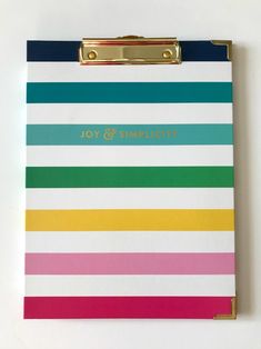 a clipboard with the words virginia joy on it in gold lettering and colorful stripes