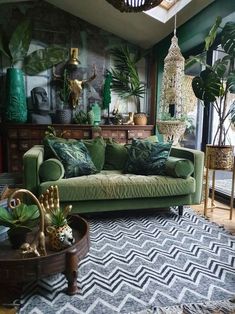 a living room filled with green furniture and lots of plants on top of the walls