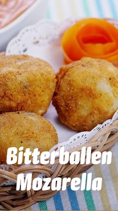 some food that is in a basket on a table with carrots and dipping sauce