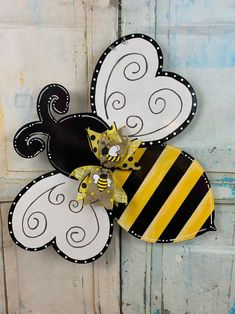 a paper flower with a bee on it hanging from the side of a wooden door