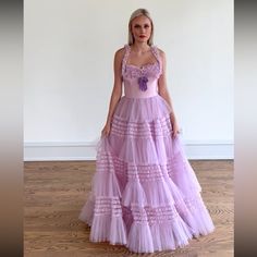 a woman in a purple dress standing on a wooden floor