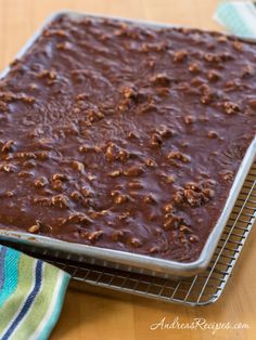 a pan filled with brownie batter on top of a cooling rack next to a towel