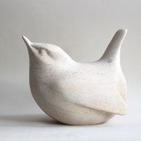 a white ceramic bird sitting on top of a table