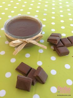 a jar of chocolate next to some pieces of chocolate on a polka dot tablecloth