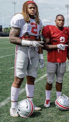 two football players standing next to each other on a field