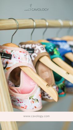 several pairs of baby shoes are hanging on a rack