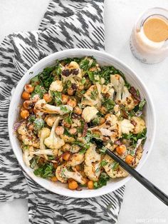 a white bowl filled with cauliflower and chickpeas