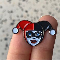 a close up of a person's hand holding a ring with a clown face on it