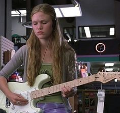 a girl with headphones playing an electric guitar