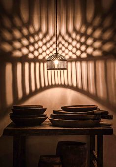 a table topped with lots of plates under a light fixture