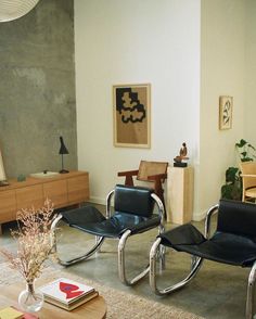 two black leather chairs sitting in a living room