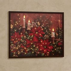 a christmas scene with candles and poinsettis on a red background framed in black wood