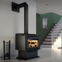 a black stove sitting in the middle of a room next to stairs and railings