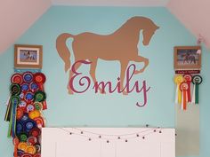 a child's bedroom with a horse wall decal on the wall and colorful ribbons hanging from the ceiling