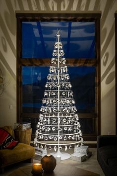 a lighted christmas tree sitting in front of a window