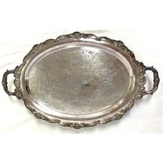 an ornate silver tray with handles on a white background