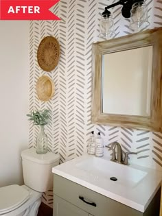 a white toilet sitting next to a bathroom sink under a wooden mirror mounted on a wall