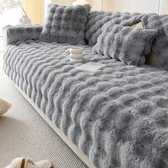 a gray bed with two pillows on top of it