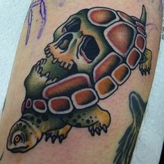 a close up of a person's arm with a tattoo on it and a turtle