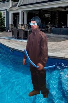 a man standing in the water with a pool hose