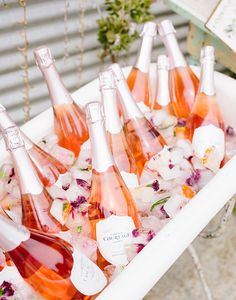 there are many bottles of wine in the ice cubes on the table with flowers